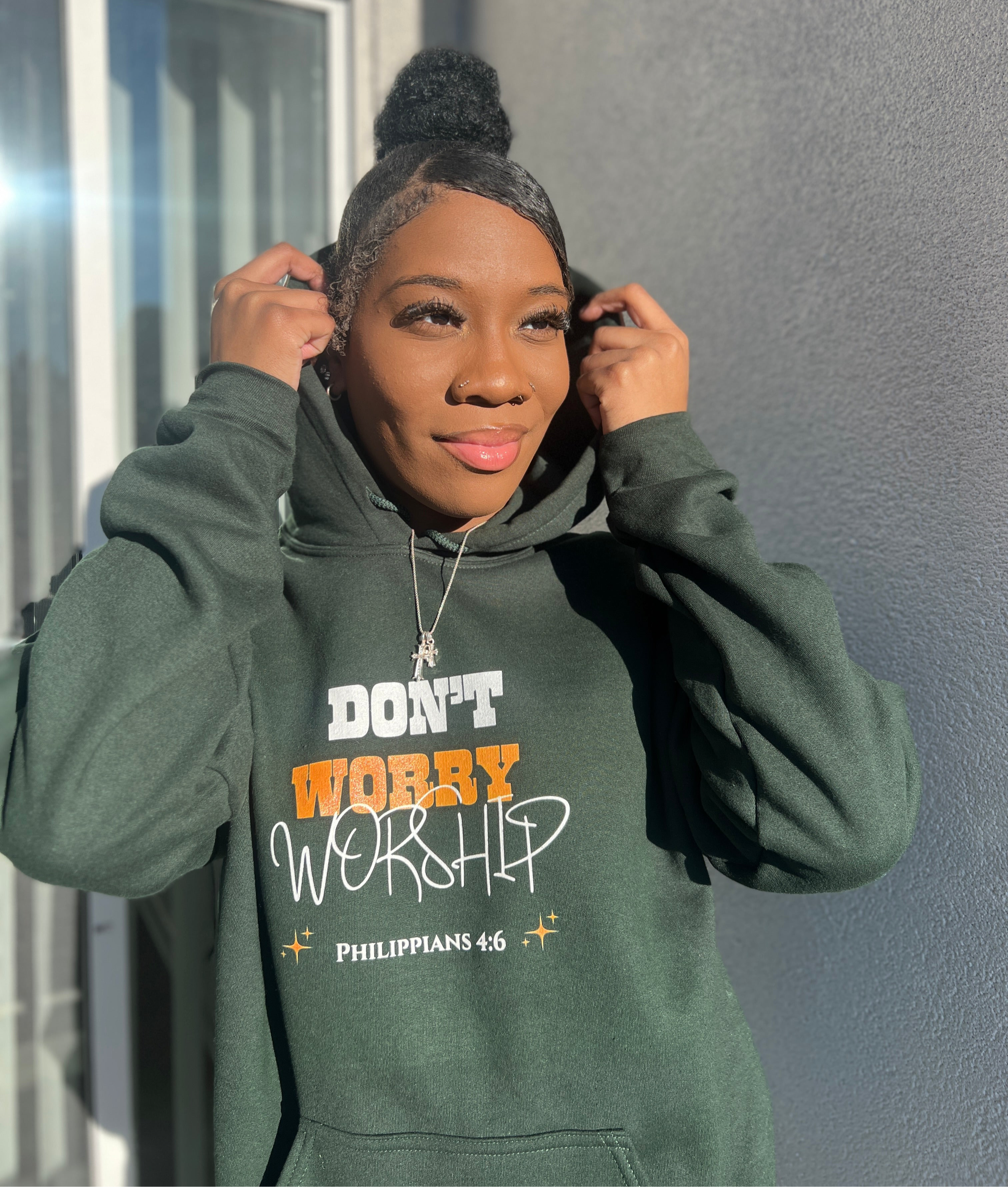 girl wearing Christian streetwear hoodie in green featuring the Don't Worry Worship minimalist design for a modern faith-based look