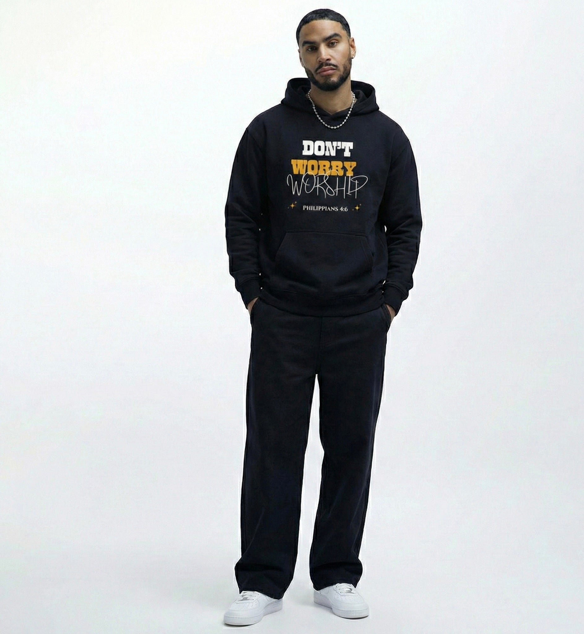 Man wearing a faith based black hoodie with dont worry worship text with philippians 4:6